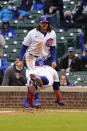 Chicago Cubs' Ildemaro Vargas, bottom, slides safely into home plate as teammate Jake Marisnick, top, stands nearby during the third inning of the first baseball game of a doubleheader against the Los Angeles Dodgers Tuesday, May, 4, 2021, in Chicago. (AP Photo/David Banks)