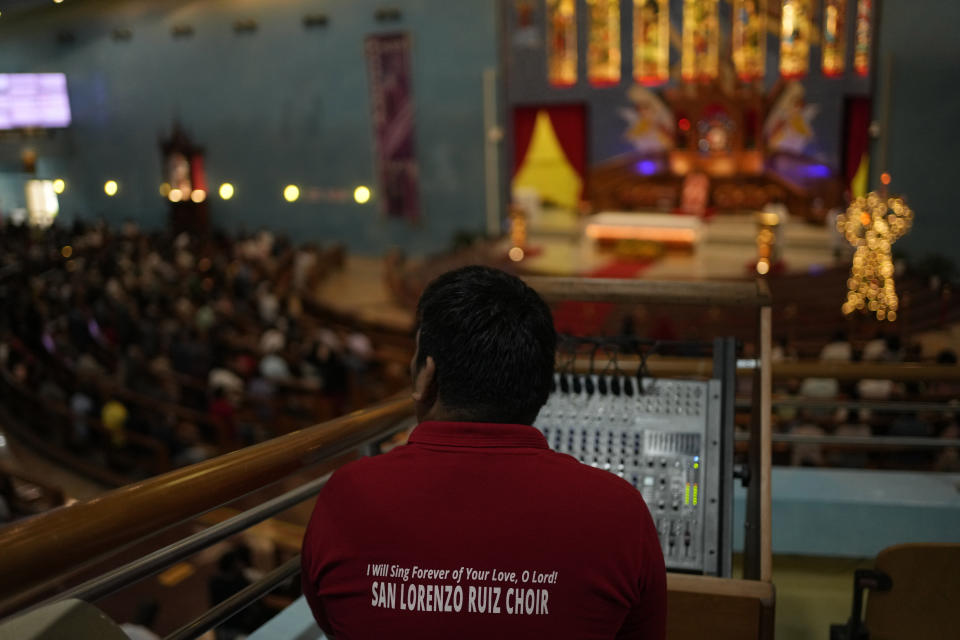 Α sound engineer works during a liturgy at the Catholic Church, Our Lady of the Rosary, at the Religious complex, in Doha, Qatar, Friday, Dec. 9, 2022. (AP Photo/Thanassis Stavrakis)