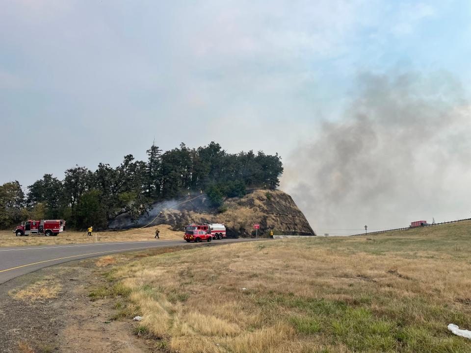 Firefighters work a fire near I-5 south of Eugene on Saturday afternoon.