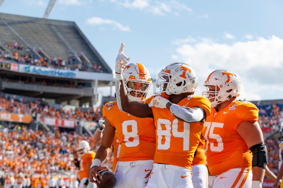 Tennessee quarterback Nico Iamaleava (8), wide receiver Kaleb Webb (84) and offensive lineman Jackson Lampley (75) celebrate a touchdown against Iowa during the 2024 Camping World Stadium.