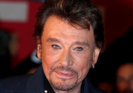 FILE PHOTO: French singer Johnny Hallyday waves as he arrives at the Cannes festival palace to attend the NRJ Music Awards in Cannes January 28, 2012. REUTERS/Eric Gaillard/File Photo