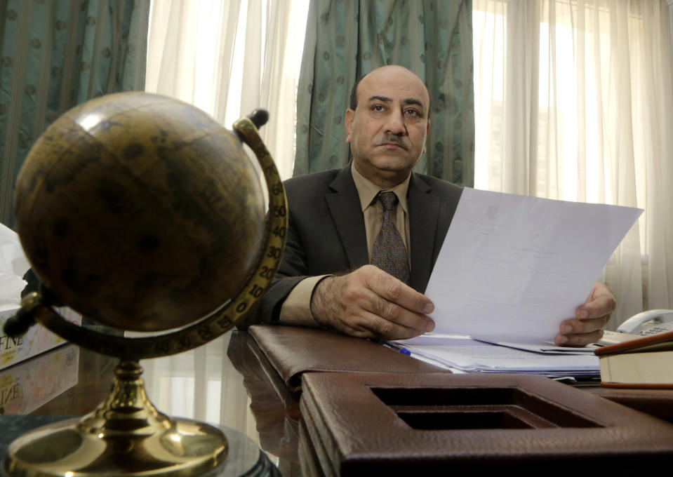 In this Tuesday, April 16, 2014 photo, Hesham Genena, the head of Egypt's oversight body, holds documents at his office in Cairo, Egypt. Genena has created uproar simply because he decided to actually do his job. The head of one of Egypt’s foremost government oversight agencies, he says he has uncovered billions of dollars-worth of corruption, including in the country’s most untouchable institutions, including the police, intelligence agencies, and the judiciary.(AP Photo/Amr Nabil)