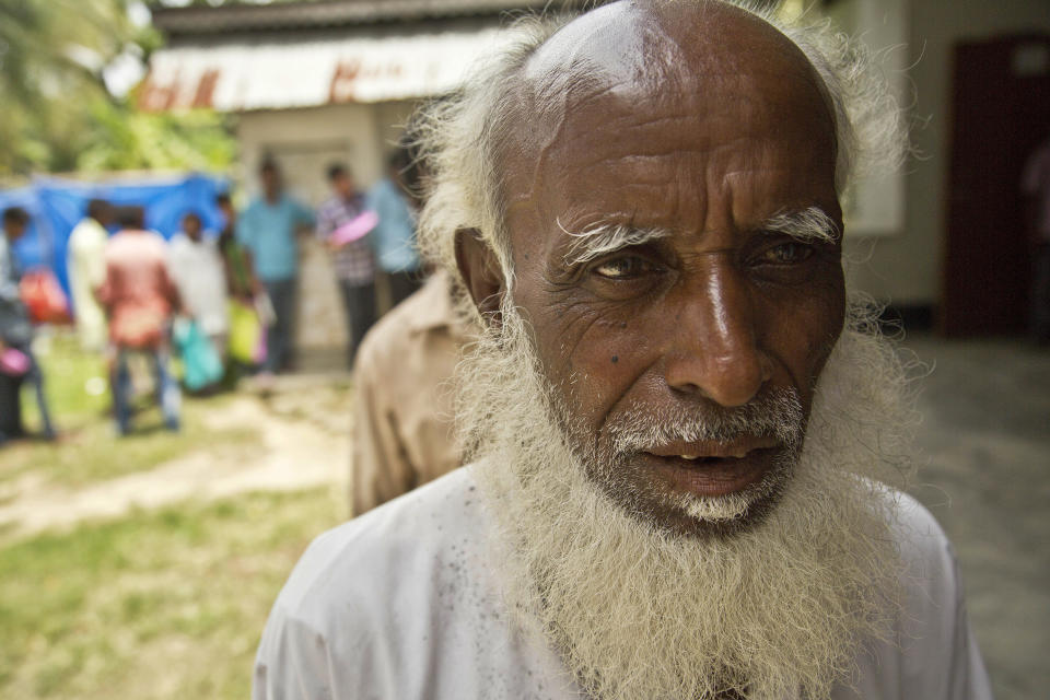 An elderly man, whose name did not appear in the National Register of Citizens (NRC) draft, stands in a queue to collect forms to file appeals in Mayong, 45 kilometers (28 miles) east of Gauhati, India, Friday, Aug. 10, 2018. A draft list of citizens in Assam, released in July, put nearly 4 million people on edge to prove their Indian nationality. Nativist anger churns through Assam, just across the border from Bangladesh, with many believing the state is overrun with illegal migrants. (AP Photo/Anupam Nath)