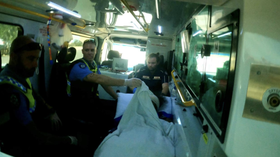 A man is pictured in an ambulance with WA Police