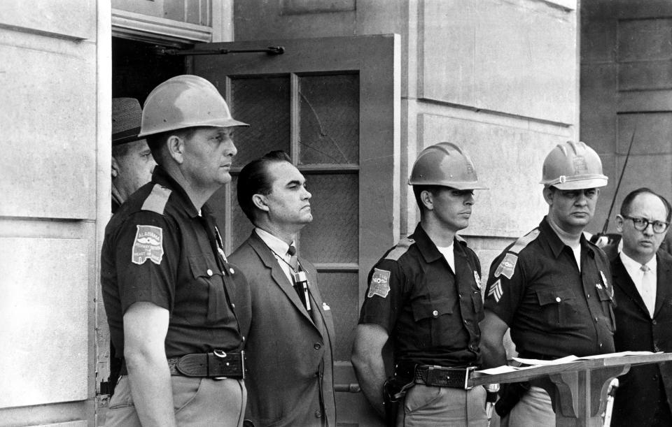 FILE - In this June 11, 1963 file photo, Gov. George Wallace blocks the entrance to the University of Alabama as he turned back a federal officer attempting to enroll two black students at the university campus in Tuscaloosa, Ala. The University of Alabama at Birmingham has removed the name of four-term governor and presidential candidate George C. Wallace from a campus building over his support of racial segregation. A resolution unanimously approved by trustees Friday, Feb. 5, 2021, said Wallace rose to power by defending racial separation and stoking racial animosity. (AP Photo/File)