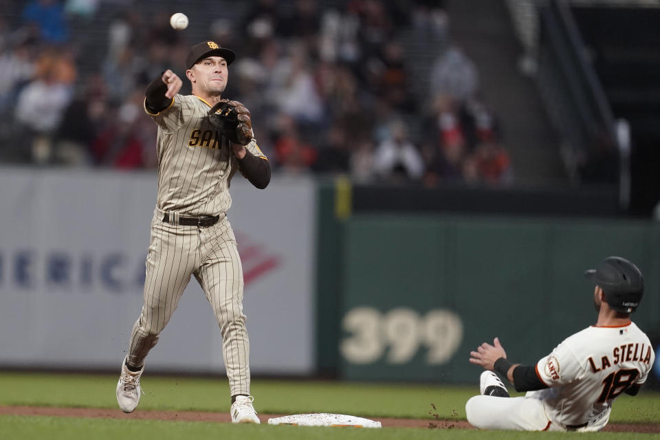 San Diego Padres second baseman Adam Frazier, left, throws to first base after forcing San Francisco Giants' Tommy La Stella, right, out at second base on a double play hit into by Buster Posey during the first inning of a baseball game in San Francisco, Wednesday, Sept. 15, 2021. (AP Photo/Jeff Chiu)