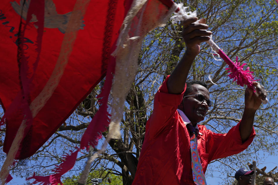 Adao das Contendas performs with the flag of the Divine Holy Spirit during the culmination of the week-long pilgrimage and celebration for the patron saint "Nossa Senhora da Abadia" or Our Lady of Abadia, in the rural area of Cavalcante in Goias state, Brazil, Sunday, Aug. 14, 2022. Devotees celebrate Our Lady of Abadia at this time of the year with weddings, baptisms and by crowning distinguished community members, as they maintain cultural practices originating from Africa that mix with Catholic traditions. (AP Photo/Eraldo Peres)