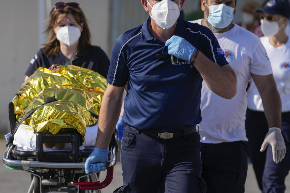 Paramedics carry an injured survivor of a shipwreck to an ambulance at the port in Kalamata town, about 240 kilometers (150 miles) southwest of Athens, Wednesday, June 14, 2023. A fishing boat carrying migrants trying to reach Europe capsized and sank off Greece on Wednesday, authorities said, leaving at least 79 dead and many more missing in one of the worst disasters of its kind this year. (AP Photos/Thanassis Stavrakis)