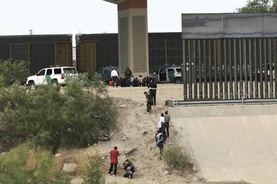 FILE - In this June 15, 2019, file photo, migrants cross the Rio Bravo illegally to surrender to the American authorities on the US - Mexico border between Ciudad Juarez and El Paso. El Paso has swiftly become one of the busiest corridors for illegal border crossings in the U.S. after years as one of the sleepiest. (AP Photo/ Photo/Christian Torres, File)