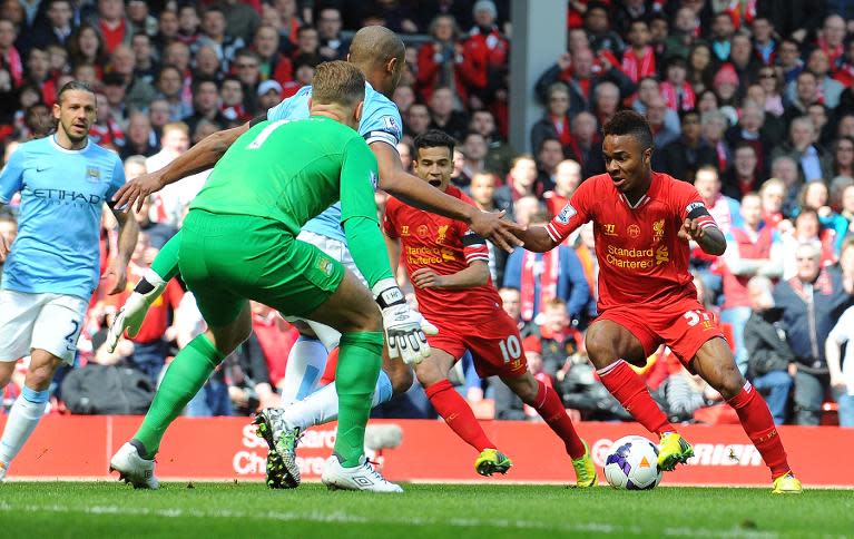 Liverpool's Raheem Sterling (R) prepares to go round Manchester City's Joe Hart (2-L) to score the opening goal during the English Premier League football match between Liverpool and Manchester City at Anfield in Liverpool on April 13, 2014