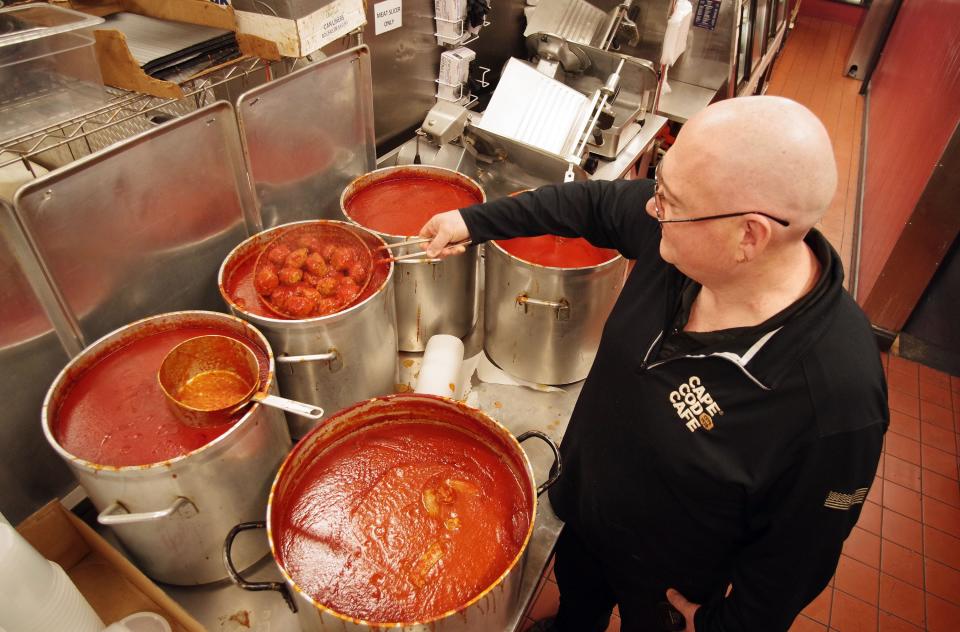 Sometimes the meatballs that the Italian Kitchen of Brockton makes are put in marinara sauce for customers. Here, kitchen manager George Pinzino inspects a batch on Thursday, Dec. 28, 2023. The big vat in the foreground contains sausage in marinara sauce.