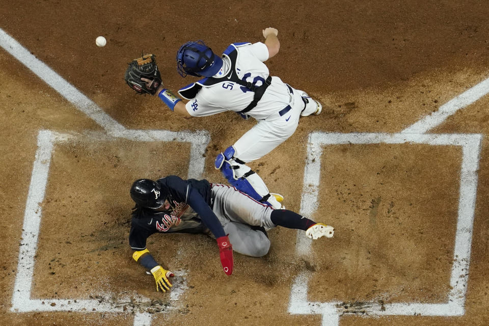 Atlanta Braves' Ronald Acuna Jr. scores past Los Angeles Dodgers catcher Will Smith on a hit by Marcell Ozuna during the first inning in Game 7 of a baseball National League Championship Series Sunday, Oct. 18, 2020, in Arlington, Texas. (AP Photo/David J. Phillip)