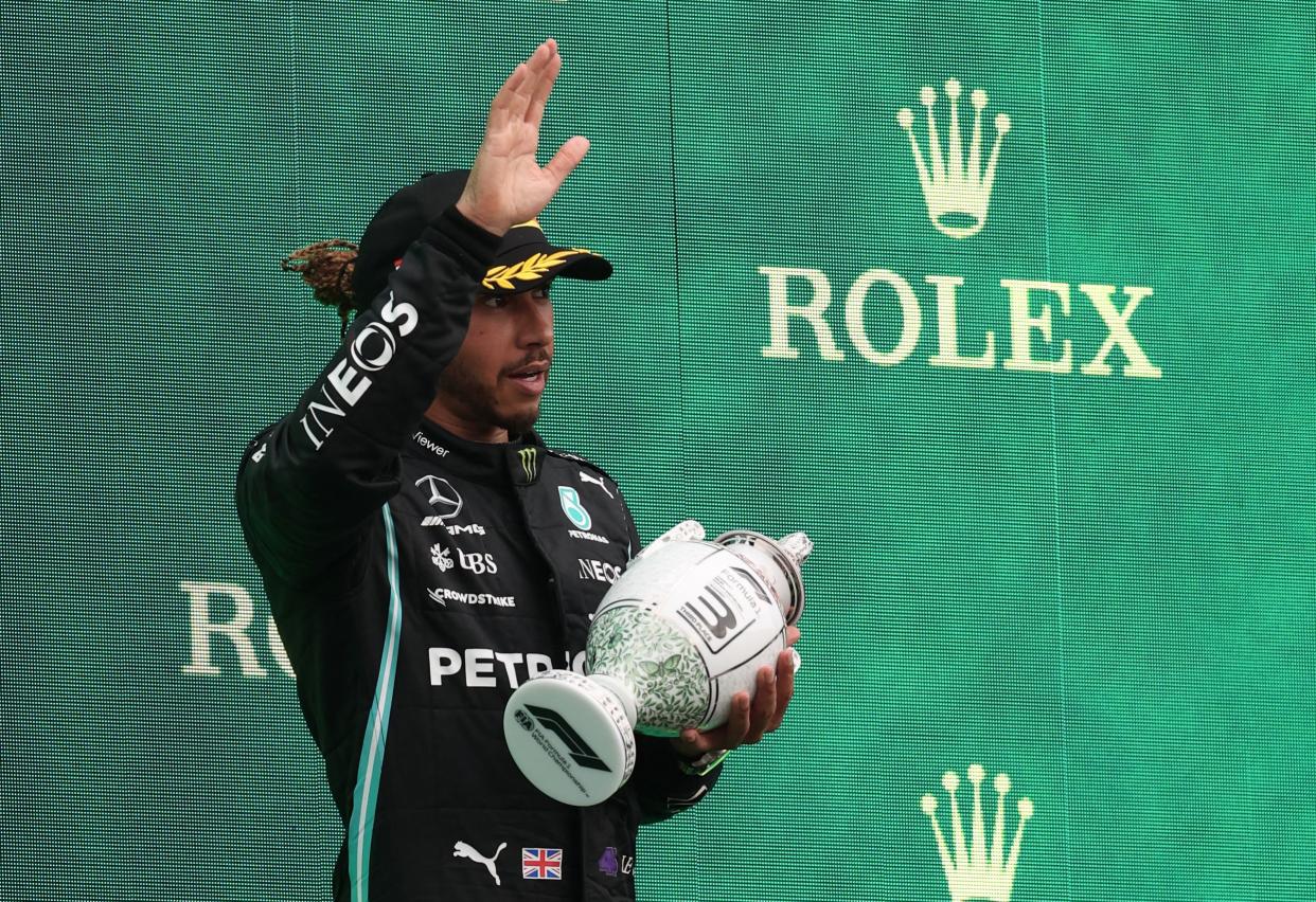 Third placed Mercedes' British driver Lewis Hamilton celebrates on the podium after the Formula One Hungarian Grand Prix.