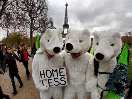 Three environmentalists wear polar bear costumes as they take part in a demonstration near the Eiffel Tower in Paris, France, as the World Climate Change Conference 2015 (COP21) continues near the French capital in Le Bourget, December 12, 2015. REUTERS/Mal Langsdon
