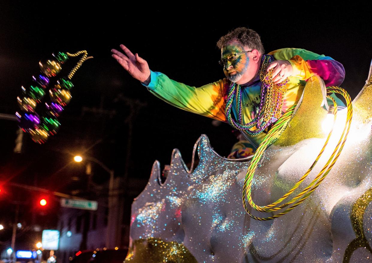 A costumed reveler throws Mardi Gras beads into a crowd of spectators during the Friday Night Parade in downtown Lafayette, Louisiana, on Feb. 13, 2015.