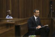 Olympic and Paralympic track star Oscar Pistorius takes notes during court proceedings at the North Gauteng High Court in Pretoria March 13, 2014. Pistorius is on trial for murdering his girlfriend Reeva Steenkamp at his suburban Pretoria home on Valentine's Day last year. REUTERS/Themba Hadebe/Pool (SOUTH AFRICA - Tags: SPORT CRIME LAW ATHLETICS)