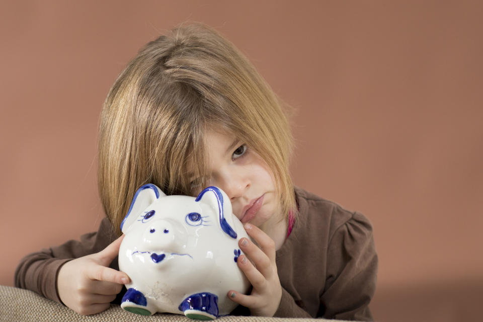 Girl poses with a piggy bank. (Source: Getty)