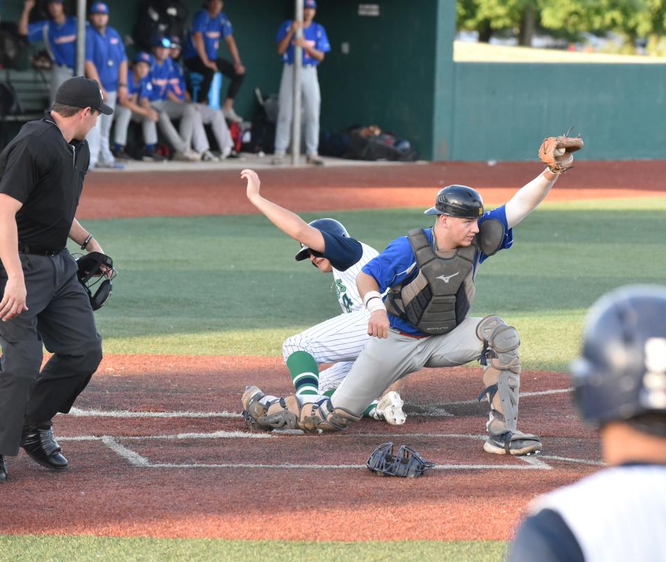 Michigan Monarchs' Sam Busch is out at home on a force play while Lima Locos' catcher Brayden White holds his foot on home while making the catch.
