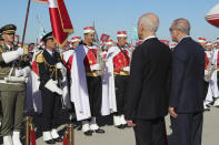 Turkey's President Recep Tayyip Erdogan, right, and Tunisian President Kais Saied review the honor guard at the airport, in Tunis, Tunisia, Wednesday, Dec. 25, 2019. Erdogan with top Turkish officials is on an unannounced visit to Tunisia to meet Saied. (Turkish Presidency via AP, Pool)
