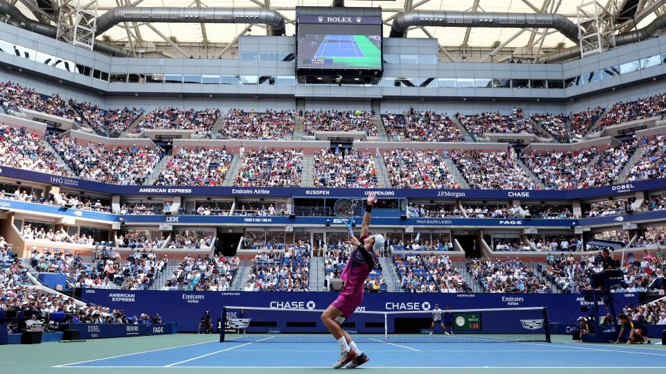 Jack Draper serves against Alex de Minaur on Arthur Ashe Stadium