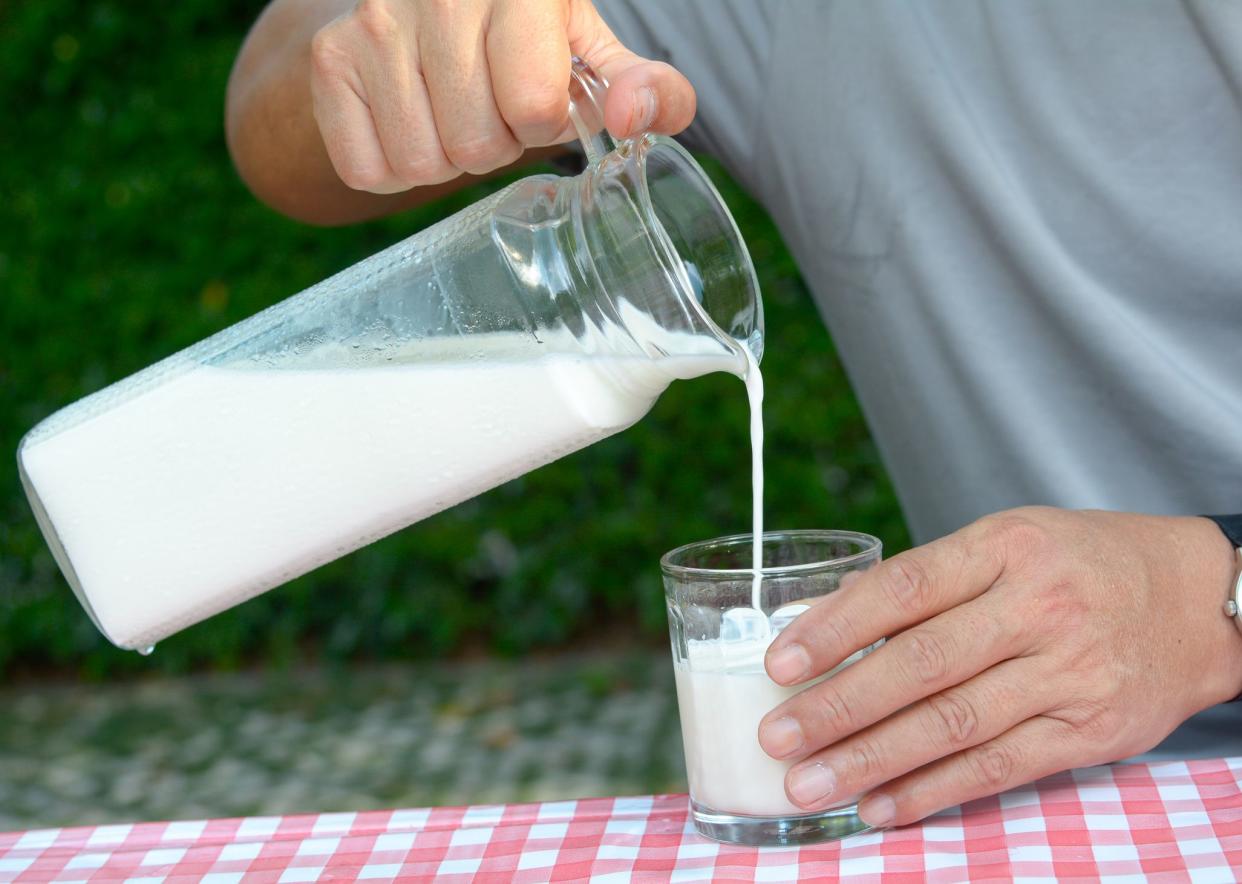 Hand on pour milk to glass