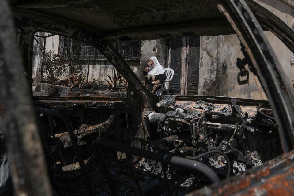 A Palestinian woman sits outside her torched home, days after it was set on fire by Jewish settlers, in the West Bank town of Turmus Ayya, Saturday, June 24, 2023. Israeli settlers entered the town, setting fire to Palestinian cars and homes after four Israelis were killed by Palestinian gunmen in the northern West Bank on Tuesday.
