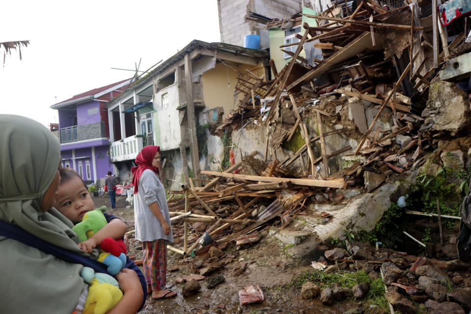 Residents inspect houses damaged by Monday's earthquake in Cianjur, West Java, Indonesia Tuesday, Nov. 22, 2022. The earthquake has toppled buildings on Indonesia's densely populated main island, killing a number of people and injuring hundreds. (AP Photo/Rangga Firmansyah)