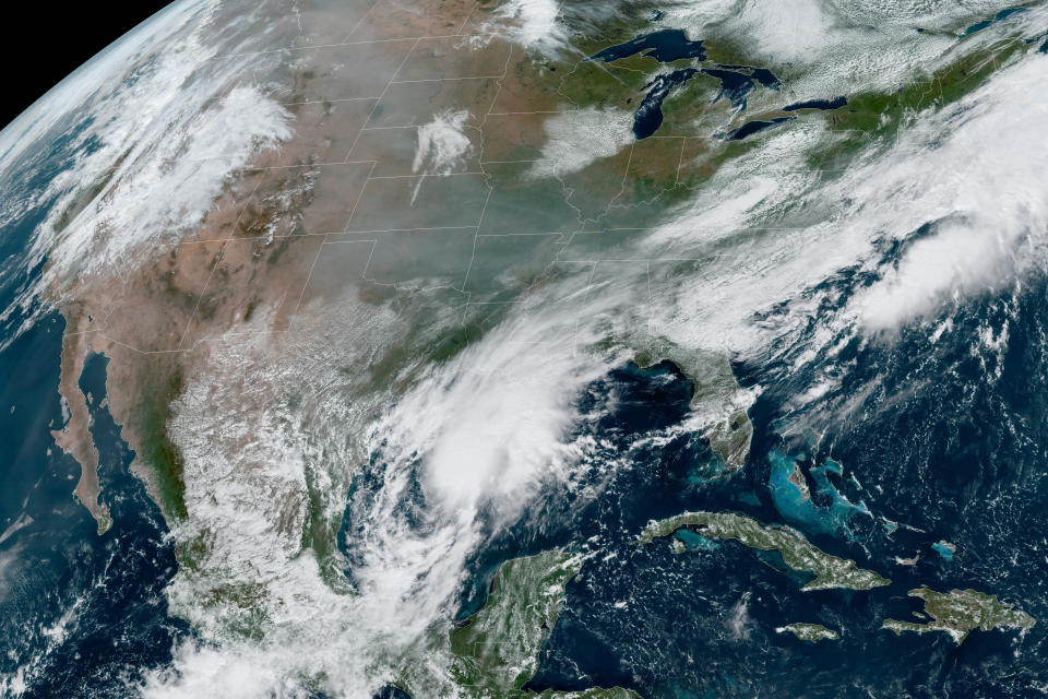 This Friday, Sept. 18, 2020 satellite image made available by the National Oceanic and Atmospheric Administration shows gray smoke from wildfires in the western United States drifting across the continent and the remnants of Hurricane Sally in the southeast. In the past week, swaths of the country have been burning and flooding in devastating extreme weather disasters. (NOAA via AP)