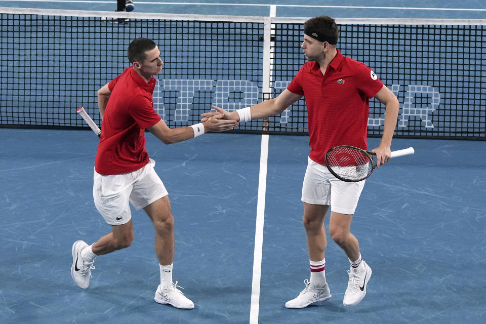 Serbia's Nikola Cacic, left, and Filip Krajinovic clap hands while playing Norway's Casper Ruud and Viktor Durasovic in their doubles match at the ATP Cup tennis tournament in Sydney, Saturday, Jan. 1, 2022. (AP Photo/Rick Rycroft)