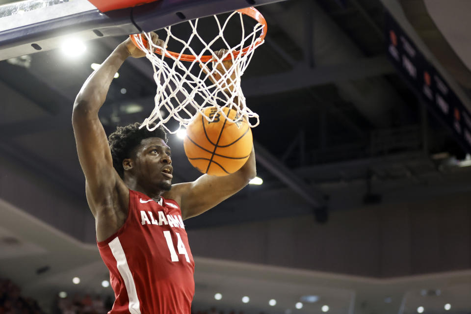 Alabama center Charles Bediako (14) slam dunks the ball against Auburn during the first half of an NCAA college basketball game, Saturday, Feb. 11, 2023, in Auburn, Ala. (AP Photo/Butch Dill)