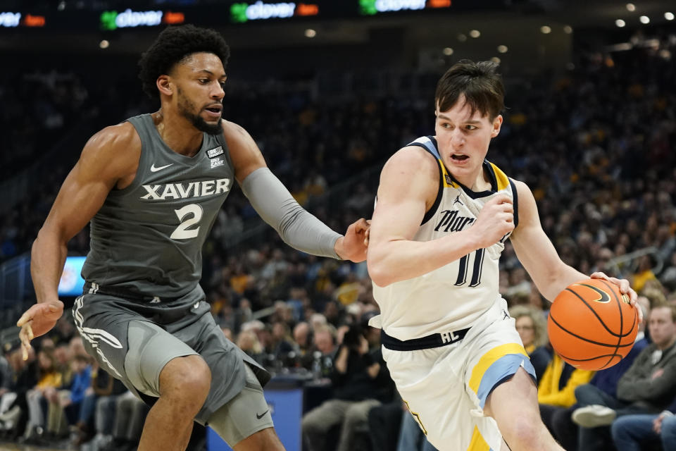 Marquette's Tyler Kolek (11) drives to the basket against Xavier's Jerome Hunter during the first half of an NCAA college basketball game Wednesday, Feb. 15, 2023, in Milwaukee. (AP Photo/Aaron Gash)
