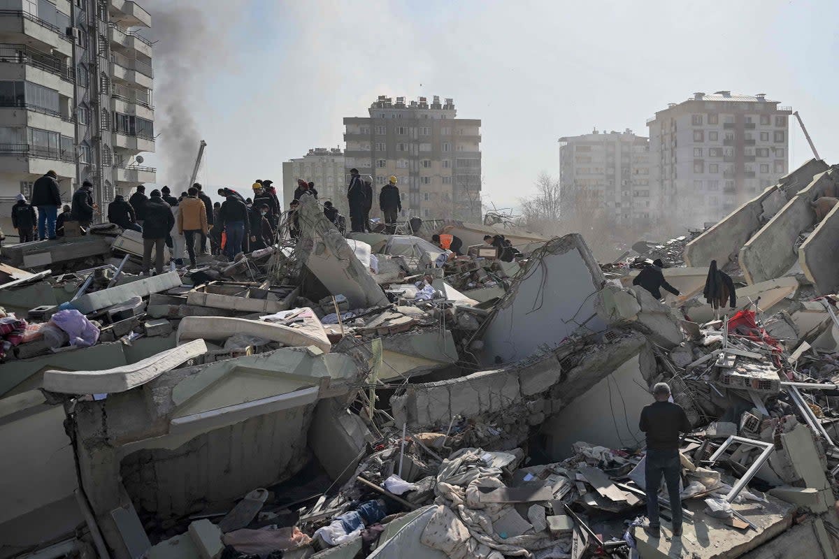 People wait as rescuers search for victims and survivors among the rubble of collapsed buildings in Kahramanmaras, on February 9, 2023, three days after a 7,8-magnitude earthquake struck southeast Turkey (AFP via Getty Images)