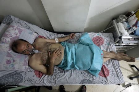 A man breathes through an oxygen mask at al-Quds hospital, after a hospital and a civil defence group said a gas, what they believed to be chlorine, was dropped alongside barrel bombs on a neighbourhood of the Syrian city of Aleppo, Syria, early August 11, 2016. REUTERS/Abdalrhman Ismail