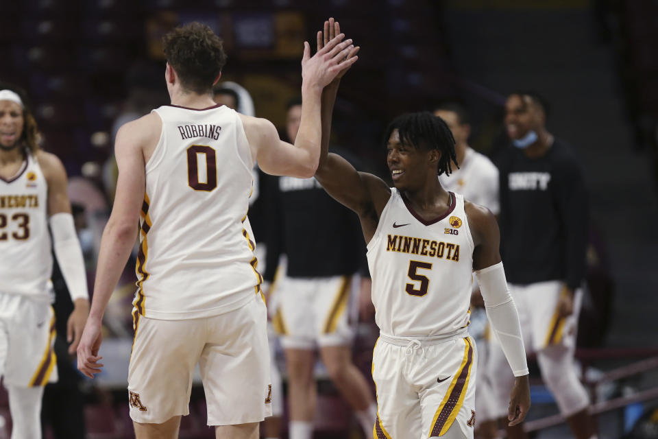 Minnesota's Marcus Carr (5) high-fives teammate Liam Robbins (0) during the second half of an NCAA college basketball game against Michigan State, Monday, Dec. 28, 2020, in Minneapolis. Minnesota won 81-56. (AP Photo/Stacy Bengs)
