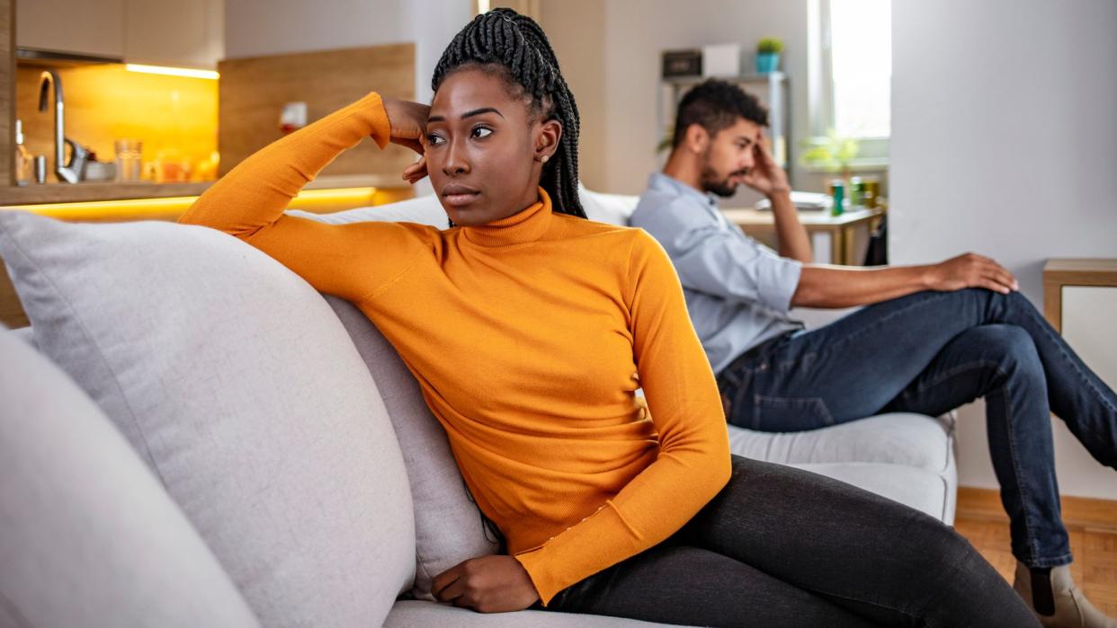 Photo of unhappy African couple having argument at home. People, relationship difficulties, conflict and family concept.