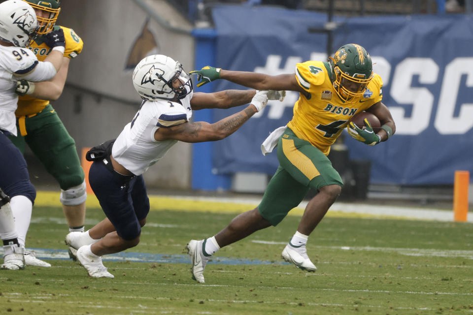 North Dakota State running back Kobe Johnson (4) breaks away from Montana State defensive back Eric Zambrano (1) for a long touchdown run during the first half of the FCS Championship NCAA college football game in Frisco, Texas, Saturday, Jan. 8, 2022. (AP Photo/Michael Ainsworth)