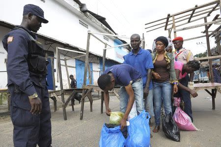 Security forces control a checkpoint outside the Ebola quarantine area of West Point as relatives carry food and essentials for their family members, in Monrovia August 23, 2014. REUTERS/2Tango