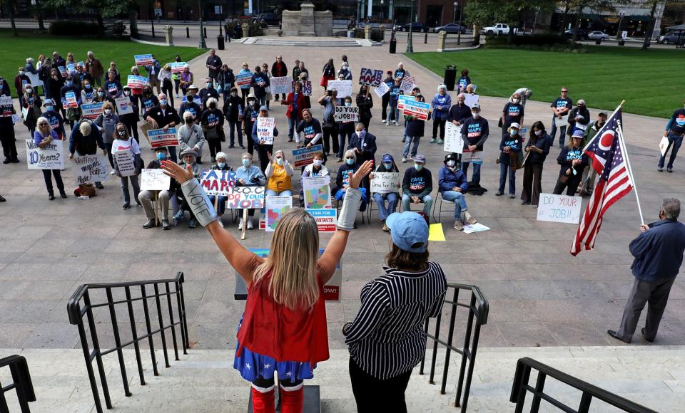 Advocates with Fair Districts Ohio rally outside the Ohio Statehouse in late October. "Voter Girl", also known as Sherry Rose, of Kent, leads participants in an "All votes matter" chant.