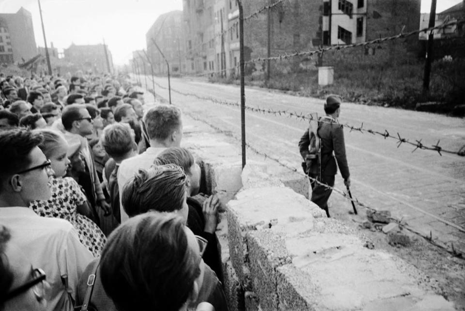 Not originally published in LIFE. A crowd of West Berlin residents watches as an East German policeman patrols the Berlin Wall in August 1961. (Paul Schutzer—Time & Life Pictures/Getty Images) <br> <br> <a href="http://life.time.com/history/berlin-wall-photos-early-days-of-the-cold-war/#1" rel="nofollow noopener" target="_blank" data-ylk="slk:Click here to see the full collection at LIFE.com;elm:context_link;itc:0;sec:content-canvas" class="link ">Click here to see the full collection at LIFE.com</a>