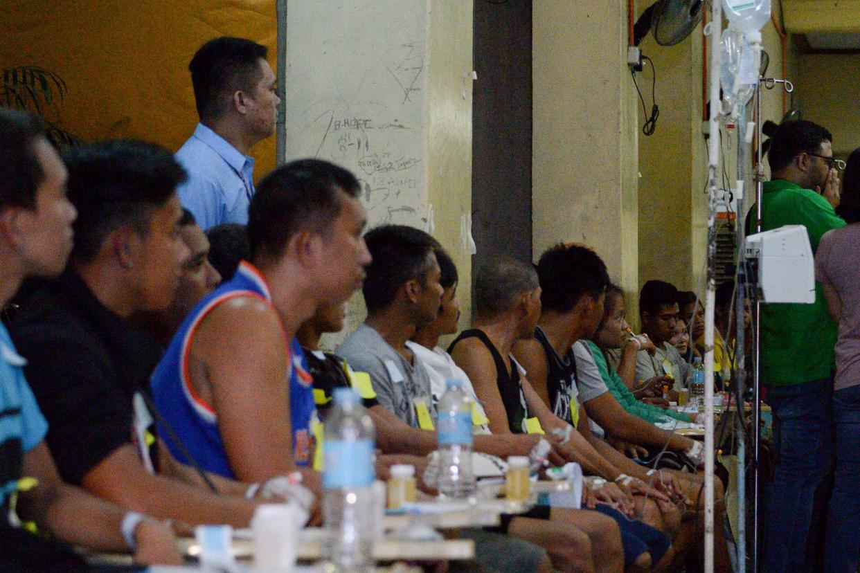 In this photo taken early December 23, 2019, residents who fell ill after drinking a coconut wine called "lambanog" sit as they wait for treatment at the Philippine General Hospital in Manila.