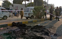 Police officers stand guard at the site where a Sri Lankan citizen was lynched by Muslim mob outside a factory in Sialkot, Pakistan, Friday, Dec. 3, 2021. A Muslim mob attacked a sports equipment factory in Pakistan's eastern Punjab province on Friday, killing a Sri Lankan over allegations of blasphemy, police said. (AP Photo/Shahid Akram)