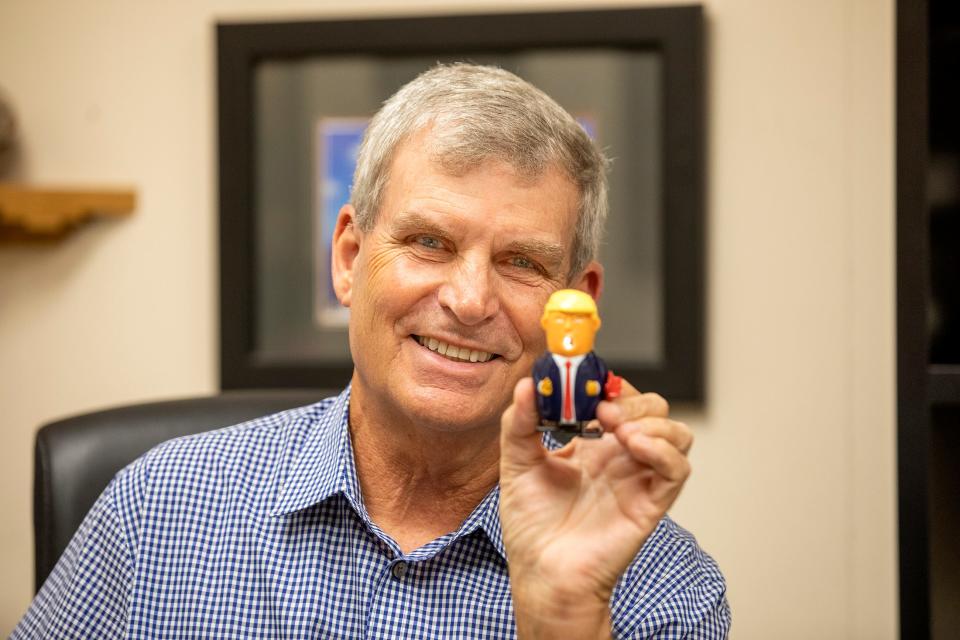 Andy Crossfield, a Democrat residing in deeply Republican Polk County, holds a spark-spitting windup Donald Trump toy in his Lakeland office on June 6.