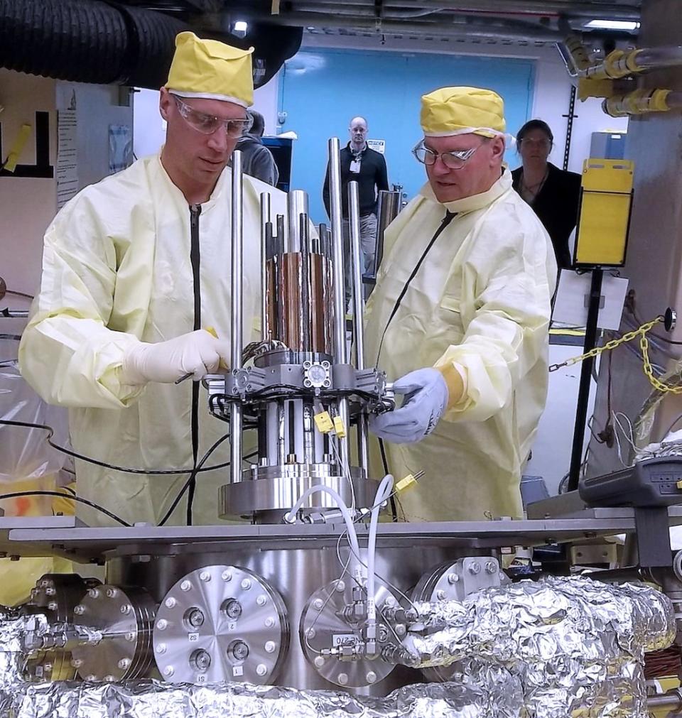 Marc Gibson, Kilopower lead engineer at NASA's Glenn Research Center, and Jim Sanzi of Vantage Partners install equipment on KRUSTY (Kilopower Reactor Using Stirling Technology) at the Nevada National Security Site (NNSS). <cite>NNSS</cite>