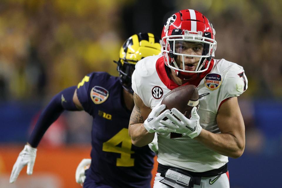 Georgia wide receiver Jermaine Burton catches a pass for a touchdown ahead of Michigan's Vincent Gray.