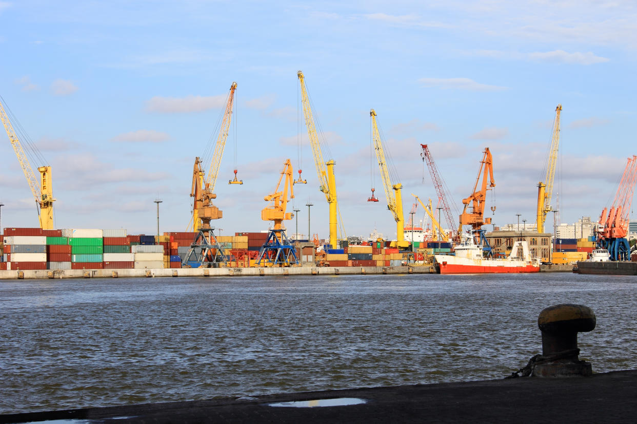 Conceptual image on trade and export of goods at the port. View of the bay, the cranes and containers.