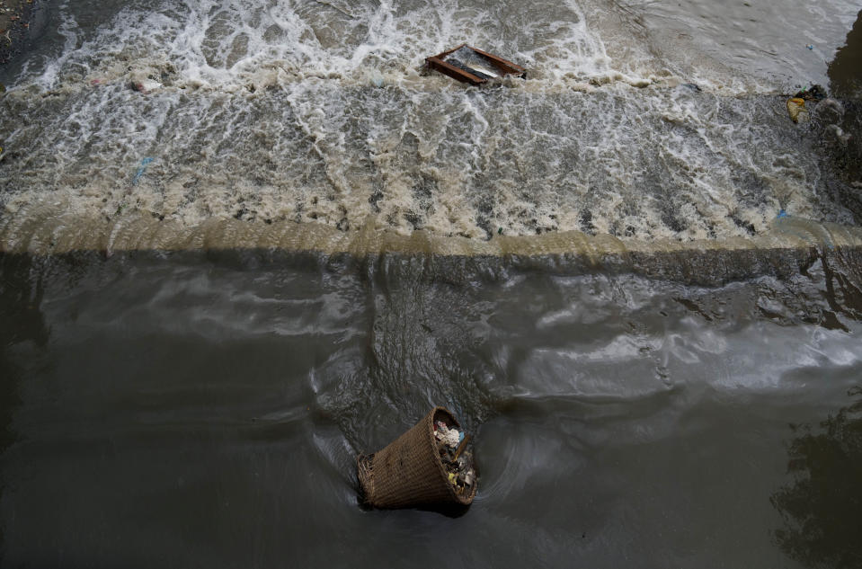 Un cesto con basura se queda varado en el cauce del río Bagmati en Katmandú, Nepal, el jueves 26 de mayo de 2022. “Se le ha hecho ya tanto daño”, dijo Madhukar Upadhya, un experto en cuencas que estudia el río de cerca, “que quizá pueda limpiarse hasta cierto punto, pero no restaurarse hasta su gloria pasada”. (AP Foto/Niranjan Shrestha)