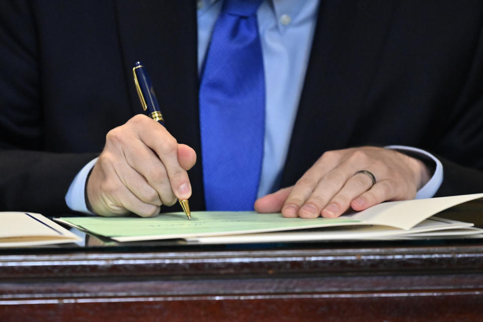 Kentucky Governor Andy Beshear signs a bill related to the American Rescue Plan Act in the Rotunda of the Kentucky State Capitol in Frankfort, Ky., Wednesday, April 7, 2021. (AP Photo/Timothy D. Easley)