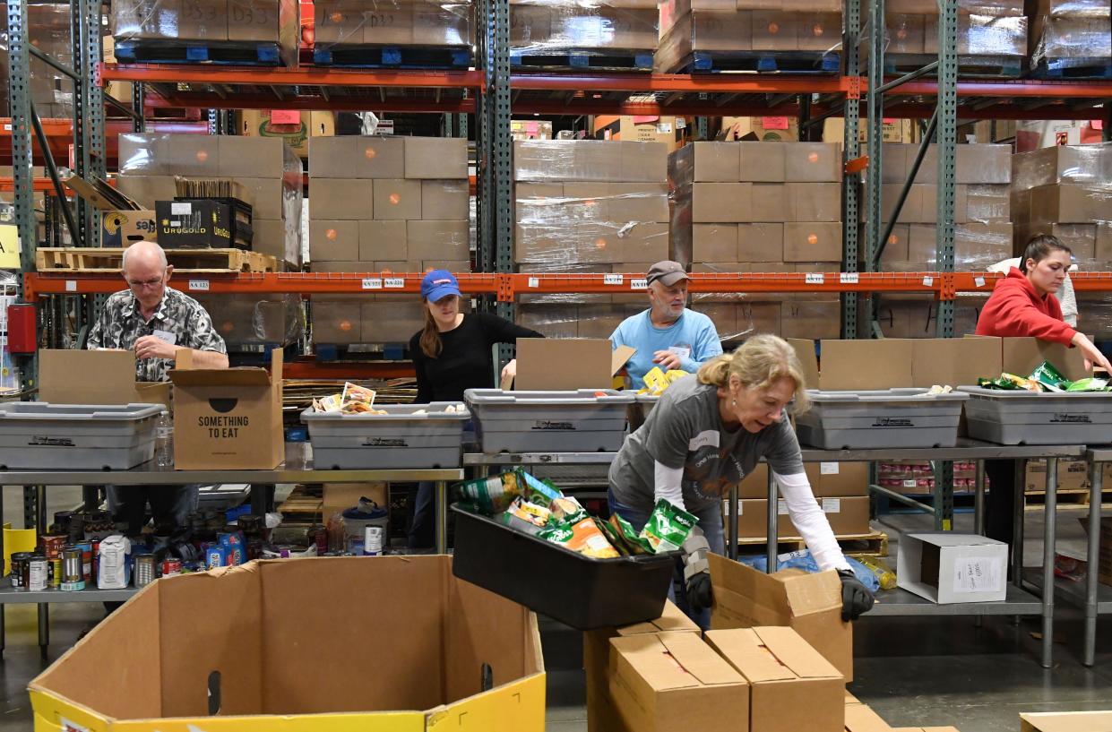 Volunteers pack boxes of food with Feeding South Dakota on Thursday, December 8, 2022, in Sioux Falls.