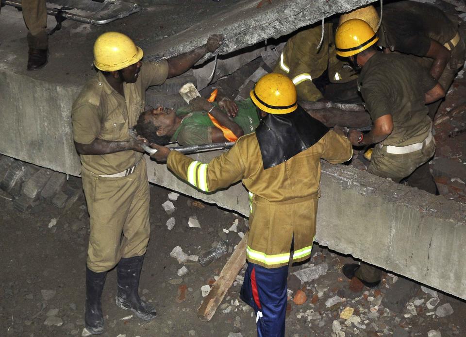 Rescue workers carry an injured man at the site of a collapsed 11-storey building that was under construction on the outskirts of the southern Indian city of Chennai