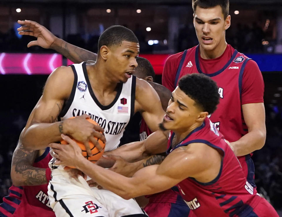 FILE - San Diego State forward Keshad Johnson, left, and Florida Atlantic guard Bryan Greenlee, front right, scramble for the ball during the first half of a Final Four college basketball game in the NCAA Tournamen, April 1, 2023, in Houston. The 2022-23 season had 54 different teams appear in the AP men’s college basketball poll and ended with no No. 1 seeds in the NCAA Tournament reaching the Final Four. (AP Photo/David J. Phillip, File)